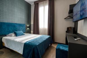 a hotel room with a bed and a flat screen tv at Hotel Astoria in Bologna