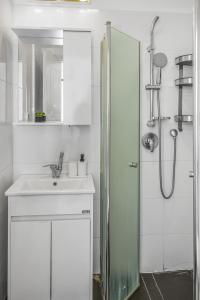 a white bathroom with a sink and a shower at IB Properties Suites in Jerusalem