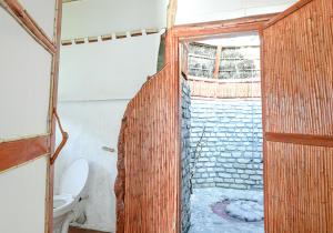 a bathroom with a shower with a toilet and a window at Kazinga Wilderness Safari Camp in Kasese