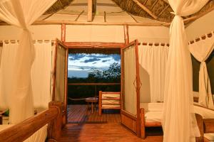 a room with a bed and a mirror on a deck at Kazinga Wilderness Safari Camp in Kasese