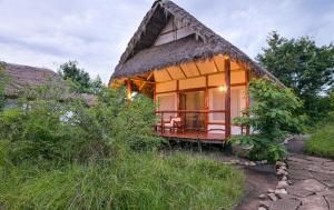 a small house with a thatched roof at Kazinga Wilderness Safari Camp in Kasese