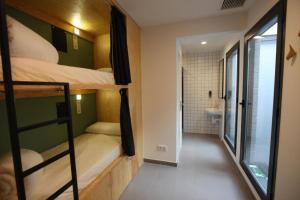 Habitación pequeña con literas y baño. en AZ The Botanic Hostel en Zaragoza