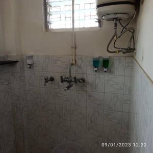 y baño con ducha alicatada y ventana. en Henry's Home, en Udaipur