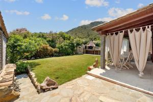 een achtertuin met een gazon en een prieel bij Villa Vittoria in Villasimius