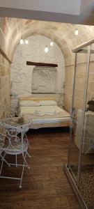 a bedroom with a bed and a table in a room at Lithos house pt 1p e 2p in Monopoli