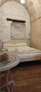 a bed in a room with a table next to it at Lithos house pt 1p e 2p in Monopoli