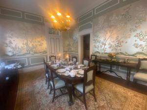 a dining room with a table and chairs and wallpaper at Corners Mansion Inn - A Bed and Breakfast in Vicksburg