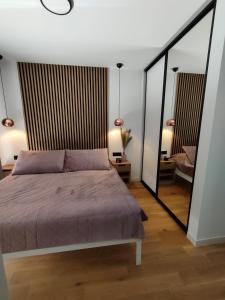 una camera da letto con un letto e un grande specchio di Seaside residence - Sunrise appartment a Kožino