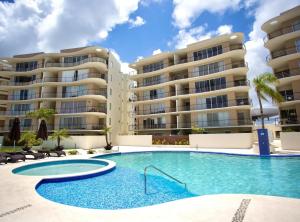 una piscina frente a dos edificios de apartamentos en 2 BR Apartment - Pool & jacuzzi, en Cancún