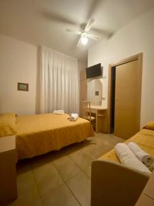 a room with two beds and a table with a desk at HOTEL DA MIMMO in Bellaria-Igea Marina