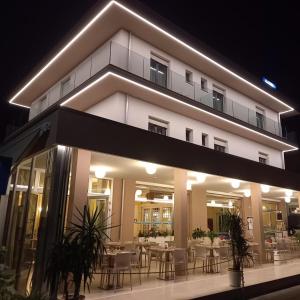 a building with tables and chairs in front of it at HOTEL DA MIMMO in Bellaria-Igea Marina