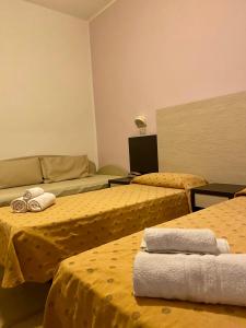 a hotel room with two beds with yellow sheets at HOTEL DA MIMMO in Bellaria-Igea Marina