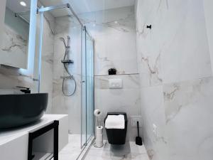 Un baño con ducha de cristal y un inodoro. en Zeus Design Apartment Schlosspark Schönbrunn, en Viena 16 fotos más
