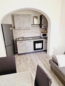 een keuken met witte kasten en een zwarte koelkast bij Dani's House in Cagliari