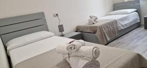 een slaapkamer met twee bedden met handdoeken erop bij Dani's House in Cagliari