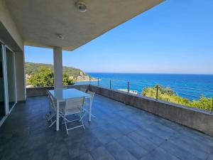 balcón con mesa y vistas al océano en Belle villa avec vue sur mer d'exception- Meria, en Meria