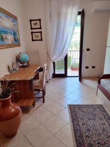 um quarto com uma secretária, uma mesa e uma janela em Casa Vacanze Villa Anna em Vibo Valentia
