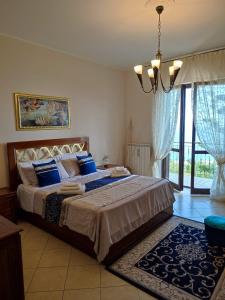 a bedroom with a large bed with blue pillows at Casa Vacanze Villa Anna in Vibo Valentia