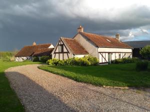 a couple of white buildings with a gravel road at La Belvinière Chambres et table d'hôtes in Tour-en-Sologne