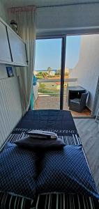 a room with two beds and a large window at La Plage Du Lido in Le Barcarès