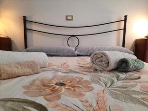 łóżko z poduszkami i ręcznikami na górze w obiekcie XX SETTEMBRE APPARTAMENTO in CENTRO w mieście Termoli