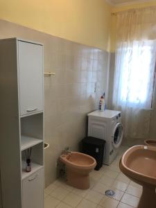 ビアンコにあるAppartamento a Bianco centroのバスルーム(トイレ、洗面台、洗濯機付)