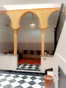 Riad Nour Travel-Les Riads Nour Resorts في مراكش: غرفة ذات اعمدة وأرضية مصدية