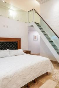 a bedroom with a white bed and a staircase at Beautiful, cozy and modern new home in Cuernavaca in Cuernavaca
