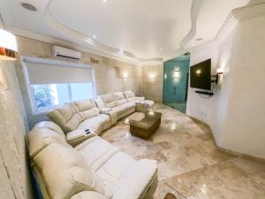 ein Wohnzimmer mit einem weißen Sofa und einem TV in der Unterkunft Beautiful, cozy and modern new home in Cuernavaca in Cuernavaca