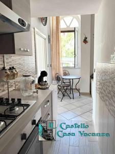 a white kitchen with a stove and a table at Il Castello casa vacanza in Salerno