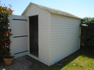 un cobertizo blanco con una puerta en un patio en MOBIL HOME dans Parc résidentiel Loisirs en Talmont