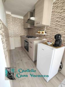 a kitchen with a white refrigerator and a stove at Il Castello casa vacanza in Salerno