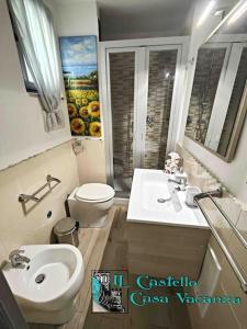 a bathroom with a sink and a toilet and a mirror at Il Castello casa vacanza in Salerno