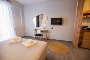 a room with a bed with two towels on it at Thea comfy living in Nea Vrasna