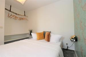 阿伦斯霍普Haus Kienappel Haus Kienappel, App 02的卧室里有一张白色的床和橙色的枕头