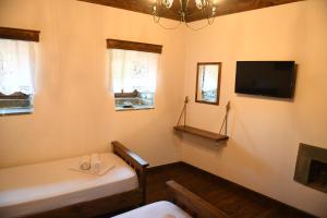 um quarto com uma cama e uma televisão na parede em Anhel Hotel em Berat