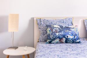 un letto con cuscini blu e bianchi e un tavolo di 1 Bedroom Beach Apartment with Balcony 2 min walk to the beach! a Costa da Caparica