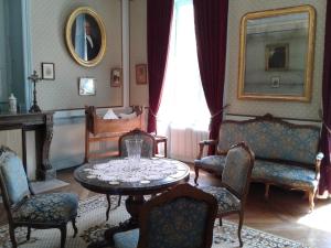 d'un salon avec une table, des chaises et une fenêtre. dans l'établissement Manoir près de La Baule, à Saint-Lyphard