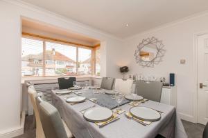 un comedor con una mesa larga y sillas en Palm Bay Coastal Retreat - Near Margate, en Margate