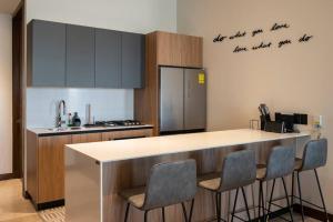 een keuken met een aanrecht met stoelen en een aanrecht bij Amazing 2-bedrooms Condo in Guadalajara