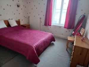 1 dormitorio con cama morada y ventana en Lovely 4-Bed House in rural West France, en Clussais-la-Pommeraie