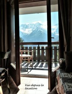 a room with a door open to a balcony with a mountain view at Studio 2 personnes - vue Mont blanc in Saint-Gervais-les-Bains