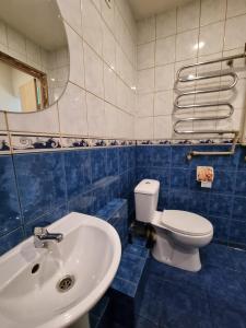 a blue and white bathroom with a toilet and a sink at Entire apartment in Pakruojis in Pakruojis