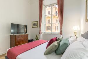 a bedroom with a bed and a tv and a window at Gentile Suites in Rome