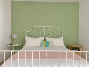 Schlafzimmer mit einem Bett mit einem grünen Kopfteil in der Unterkunft Concept Sicily in Syrakus