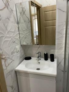 a white bathroom with a sink and a mirror at Modern Comfort In Atasehir in Istanbul