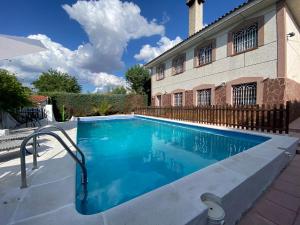 a swimming pool in front of a house at Los Caminos in Pezuela de las Torres