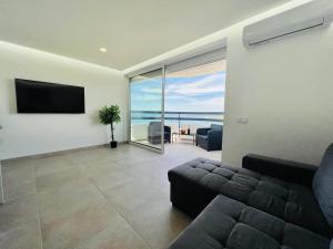 Top Ocean View Apartment - amazing sunset - modern style - pool & 200m to beach في بورتيماو: غرفة معيشة مع أريكة وإطلالة على المحيط