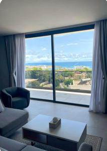 a living room with a couch and a large window at Waypoint Suites in Dakar