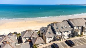 una vista aérea de una playa con casas y el océano en Carbis Bay - Luxury 3 Bed Penthouse Apartment with Sea Views Parking Sauna Balcony, en Carbis Bay